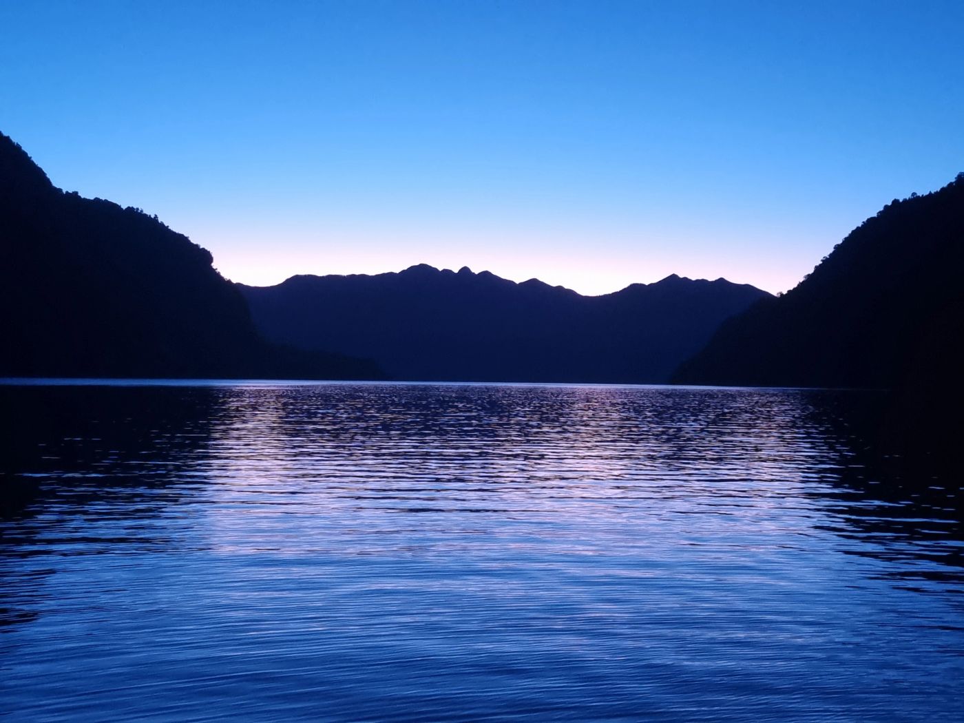 Yate navegando los fiordos de la Patagonia al atardecer